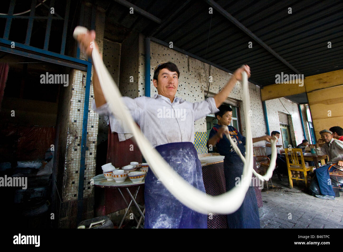 Uyghur Mann machen frische Laghman Nudeln auf dem Sonntagsmarkt in Kashgar in der Provinz Xinjiang in China Stockfoto