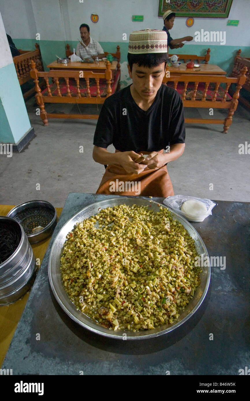 Uyghur machen Manti hinter eine riesige Schüssel mit ausfüllen Yarkand in Xinjiang Provinz China Stockfoto