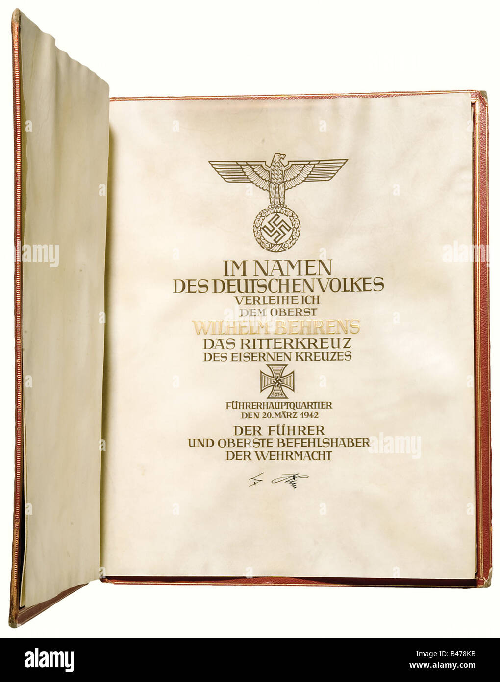Oberst Wilhelm Behrens - ein Zitat und eine Mappe zur Verleihung des Ritterkreuzes des Eisenkreuzes 1939, am 20. März 1942. Großformatige, doppelseitige Pergamentauszeichnung mit Kalligraphie in schwarzer Tinte und üppigem Gold über Hitlers Unterschrift in Tinte. Sehr guter Zustand mit frischer Farbe, das Pergament hat minimale Flecken. Im goldgestempelten, roten Lederauftragsordner. Das rechte Pergament der beiden innen ist signiert, unten "Frieda Thiersch". Die Kanten und Ecken sind stark eingedellt, der Rücken beschädigt. Generaloberst W, Stockfoto
