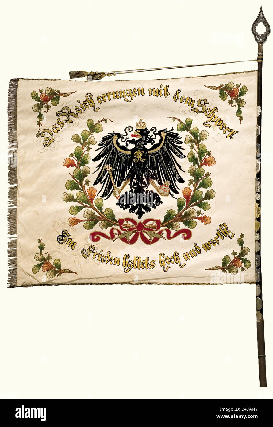 Eine Farbe des Kriegsveteranenverbandes, Hiddesdorf-Ohlendorf Weiße Seide mit einem in Gold und Farbe bestickten kaiserlichen Adler in einem Eichenblattkranz. Umlaufende Aufschrift "das Reich errungen mit dem Schwert - im Frieden haltet hoch und wert" (Das Reich wurde mit dem Schwert gewonnen - Im Frieden hoch und in Respekt gehalten). Die Namensinschrift ist auf der Rückseite in den Kaiserfarben schwarz-weiß-rot "Krieger-Verein - Hiddesdorf-Ohlendorf - 1896." (Kriegsveteranenverband - Hiddesdorf-Ohlendorf- 1896) gestickt. An drei Seiten goldene Fransen. 135 x 120 cm. Nai, Stockfoto