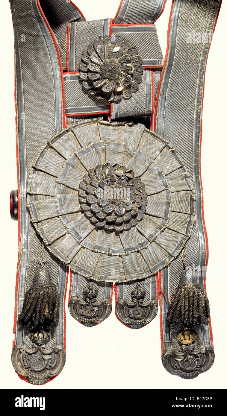Stücke von einer Lügde des Ushers, für das preussische Königshaus. Ein Bikornhut aus schwarzem Mohair der typischen Hochform, mit breiter silberner Spitze beschnitten. Seidenkakade mit Spitzverschluss, Knauf mit Spange und Landeswappenknopf. Mit schwarzer Straußenfeder beschnitten. Silberfarbene Knollenquasten. Geflochtene schwarz-silberne Schulterschnur mit bekröntem rotem Schulterbrett, die Chiffre entfernt. Großer Bandolier, ähnlich einem Bandolier eines Hofjägers. Rotes Stofffutter, silberner Spitzenbesatz, große silberne Spitze Kakade mit Knollenstickerei in der Mitte. Metallbeschläge im Stil des Rokoko, Silber, Stockfoto