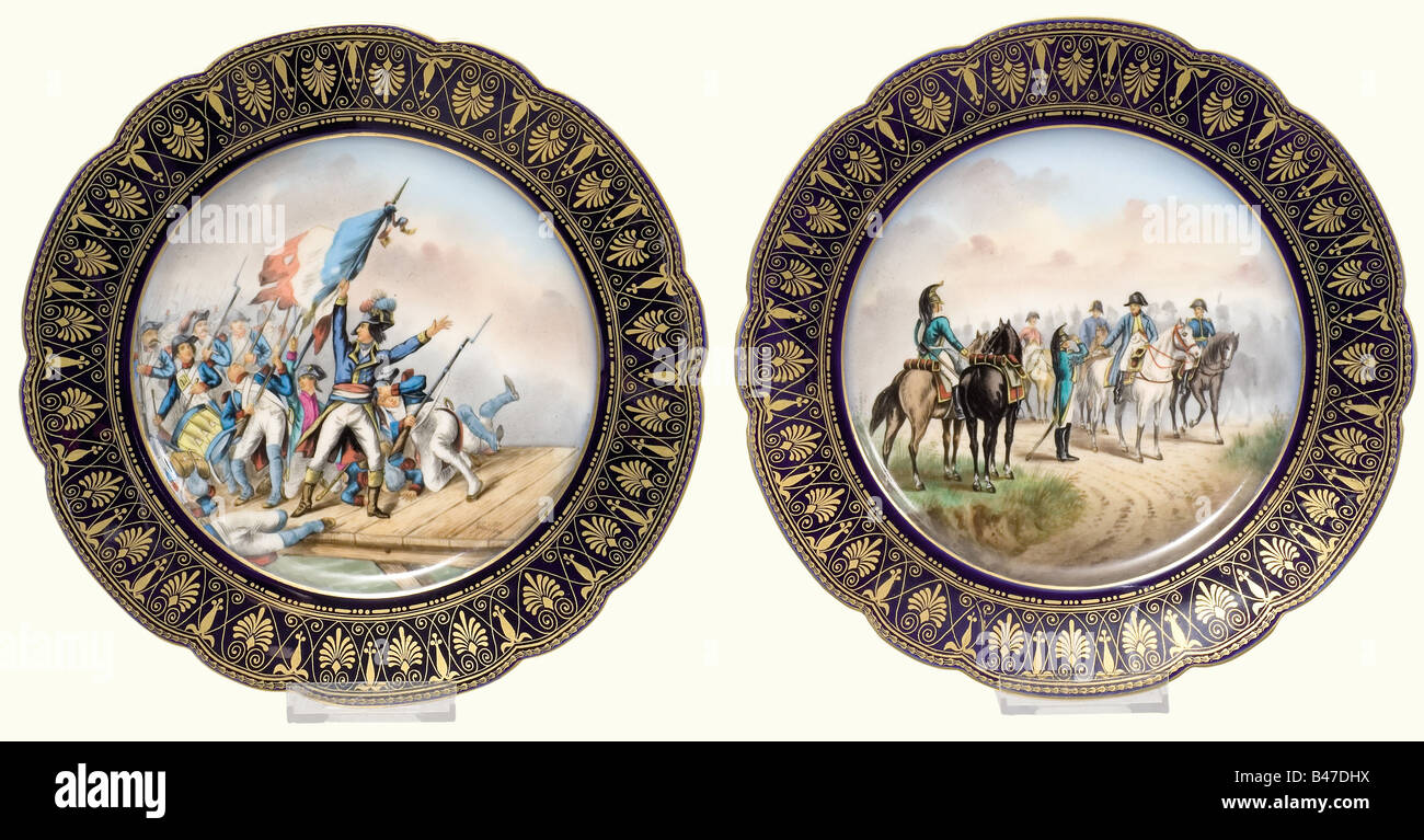 Napoleon I. - neun Platten aus Sèvres, zwischen den Jahren von 1804 und 1814. Jede Platte schmückte in der Mitte ein äußerst aufwendiges Gemälde einer der berühmten Schlachten Bonapartes, an der Grenze ein gestemmtes Muster in Gold auf dem berühmten "bleu des Sèvres". Auf der Rückseite der Name der Schlacht und eine gesteckte rote Herstellermarke. Durchmesser je 24 cm. Jede Platte zeigt eine Szene aus folgenden Ereignissen und ist entsprechend auf der Rückseite gekennzeichnet: "Toulon" (1793), "Pont S'Arcole" (1798), "Zürich" (1799), "Passage de la Linz" (1800), "Austerlitz" (1805), "Eylau" (1807), "Wagram" (1809), Stockfoto