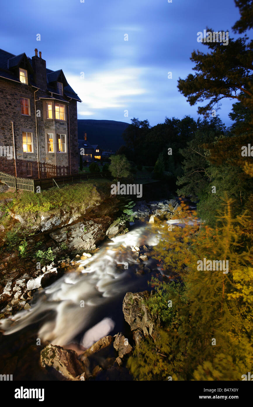 Dorf von Braemar, Schottland. Abends Blick auf das beleuchtete Clunie Wasser fließt vorbei an den Fife Arms Hotel in Braemar. Stockfoto