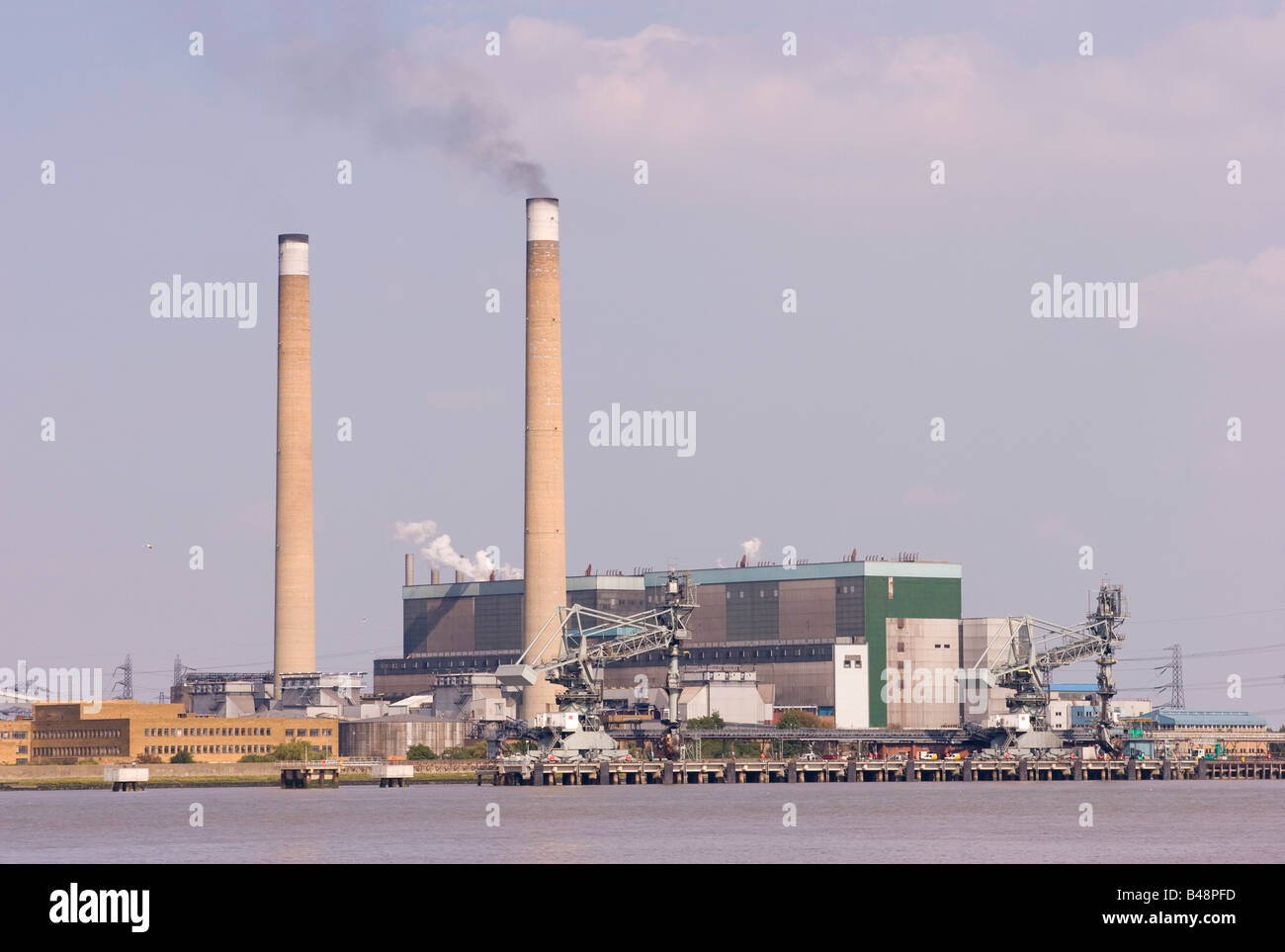 Schwarzer Rauch aus einer der beiden Schornsteine der Bellen Kohle Kohlekraftwerk am Ufer der Themse in Essex emittiert. Stockfoto
