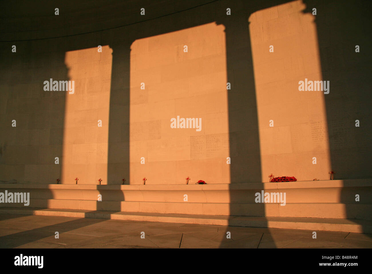 Poppie Kränze & kleine Kreuze unter einer Sonne verwöhnten Wand der Namen bei Arras Memorial, Friedhof Faubourg-Amiens, Frankreich. Stockfoto