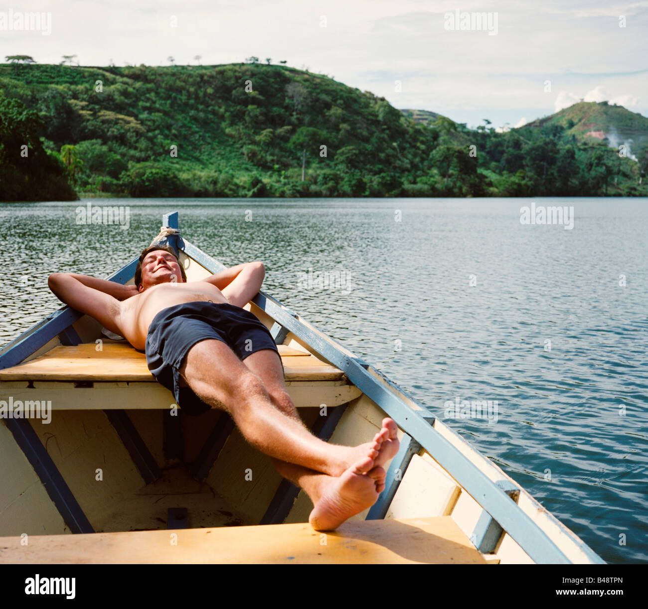 Der Mensch kehrt am Nyinambuga-See in der Ndali Lodge in Uganda zurück. Stockfoto Der Mensch kehrt am Nyinambuga-See in der Ndali Lodge in Uganda zurück. Stockfoto