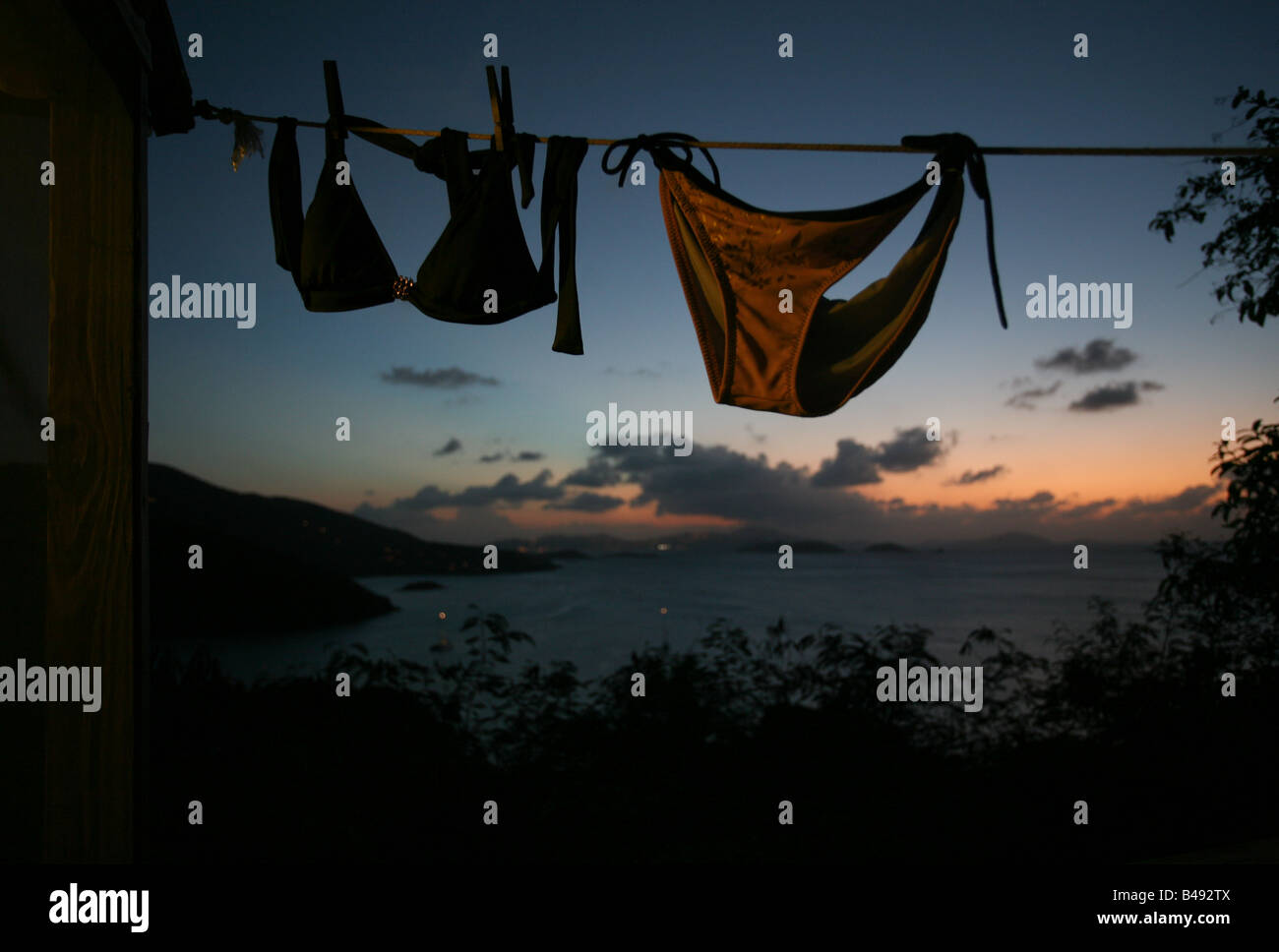 Bei Sonnenuntergang hängt ein Bikini an einer Wäscheleine einen Zeltkabine Maho Bay in St. John, US Virgin Island. Stockfoto