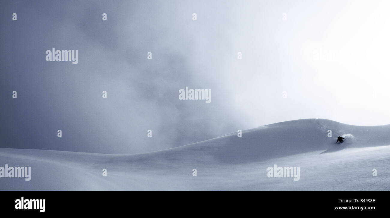 Ein einsamer Skifahrer Ski hügelige Landschaft aus einem baumlosen Bergrücken Stockfoto