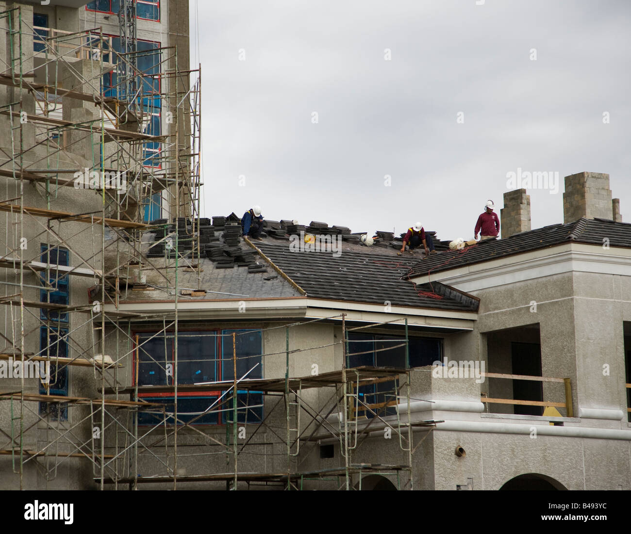 Arbeiter einstellen ein Ziegeldach auf ein Gebäude Stockfoto