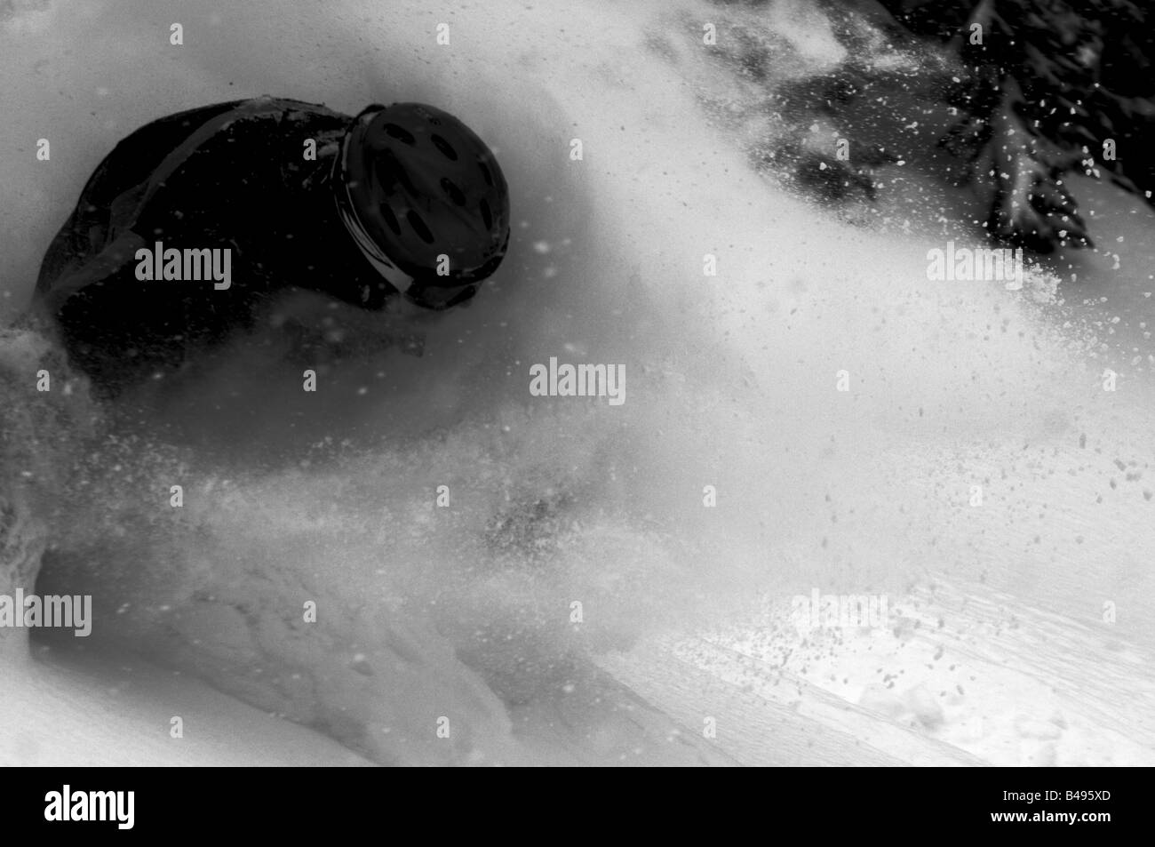 Ein Mann während eines Schneesturms in einem Spray tiefen Pulverschnee Skifahren Stockfoto