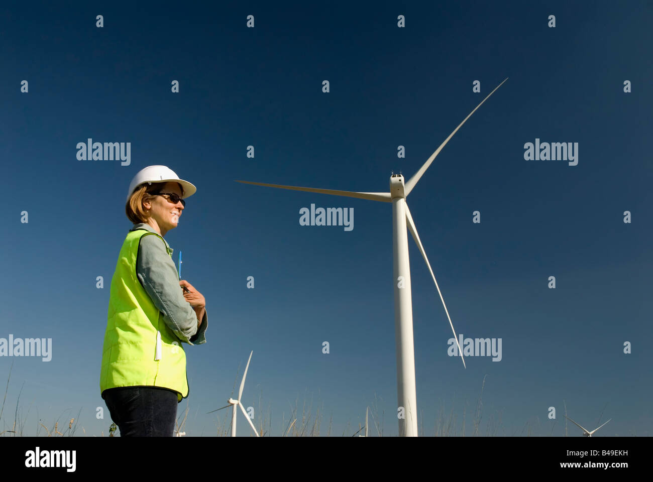 Ingenieurin grüner Kragen Arbeitsplätze neben Wind Turbine Windpark Stockfoto