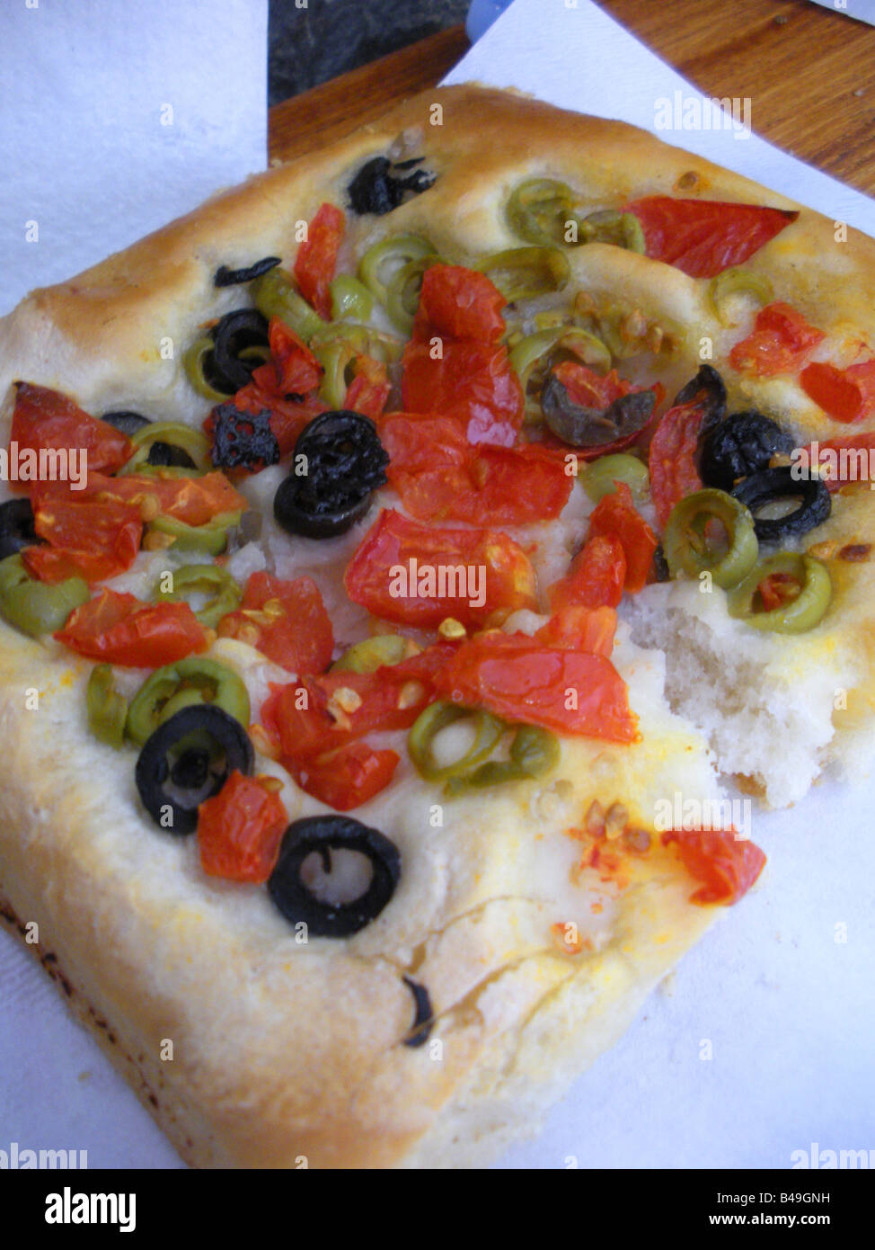 Ein Stück italienische Focaccia Brot garniert mit Tomaten und Oliven in den Cinque Terre, Italien. Stockfoto