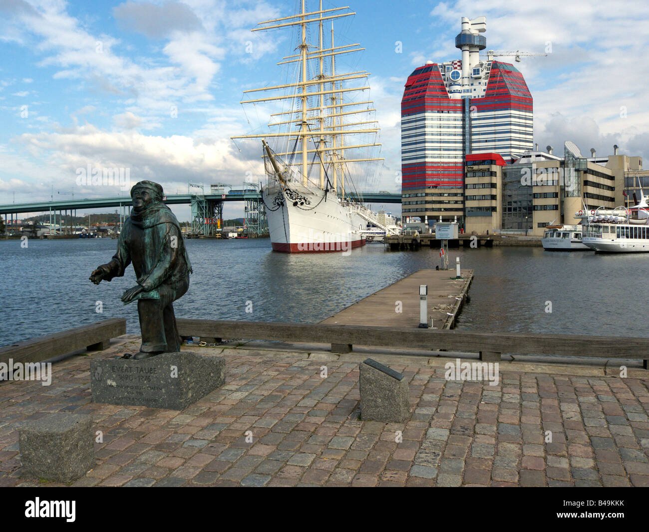 Die Statue von Evert Taube im Hafen von Göteborg mit Segeln Schiff Viking hinter und der berühmte Utkiken Turm weiter zurück. Stockfoto