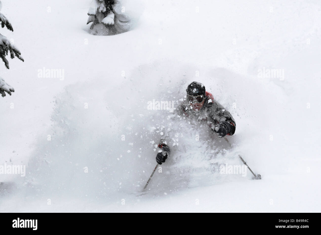 Ein Skifahrer im Tiefschnee mit einem großen Gesicht geschossen von Schnee Stockfoto