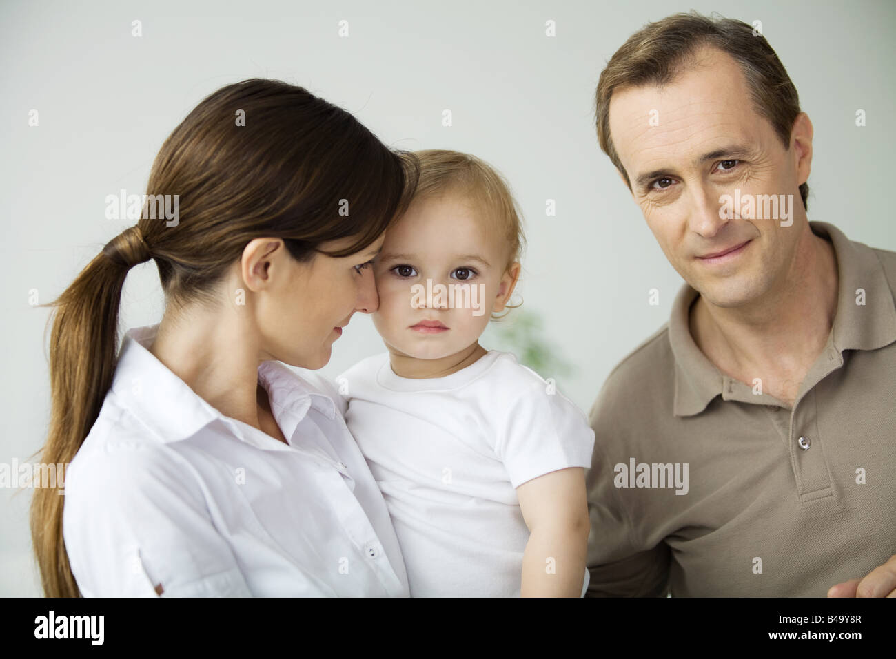 Mann neben Frau und Kleinkind lächelt in die Kamera Stockfoto