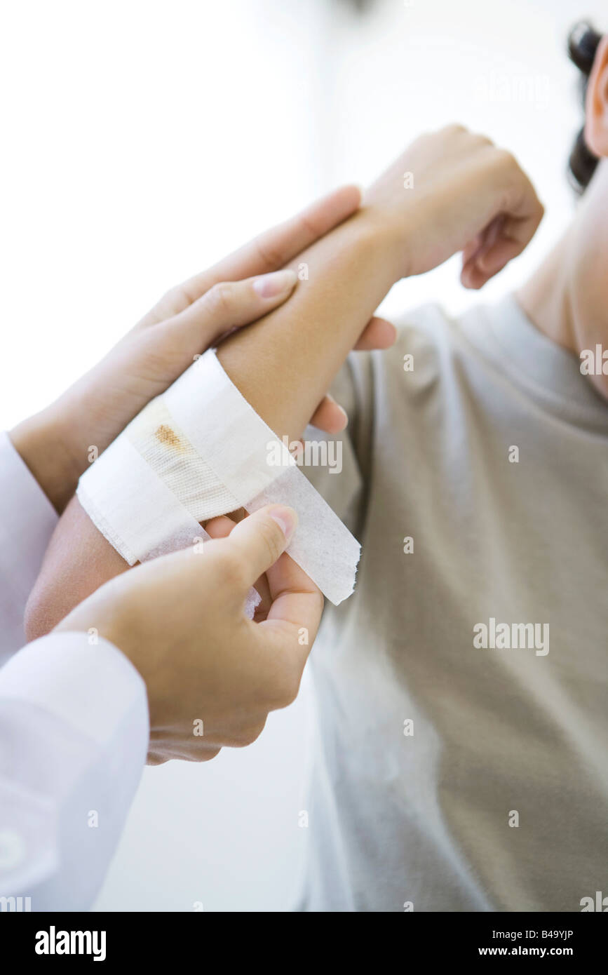 Arzt Anwendung Gaze Kindes Arm, beschnitten, Ansicht Stockfoto