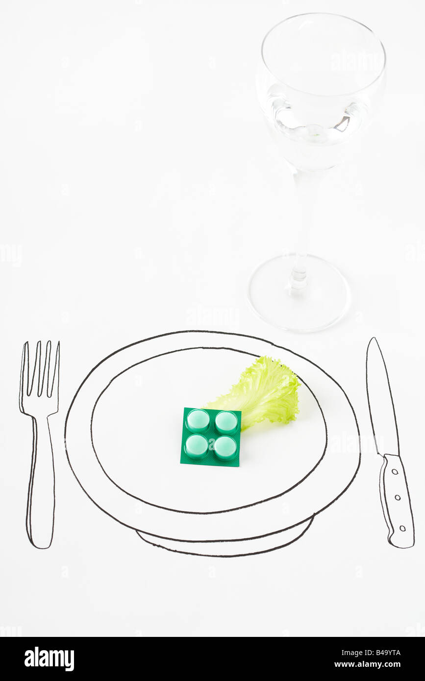 Pillen und einzelnes Blatt Salat auf Zeichnung Platte Stockfoto