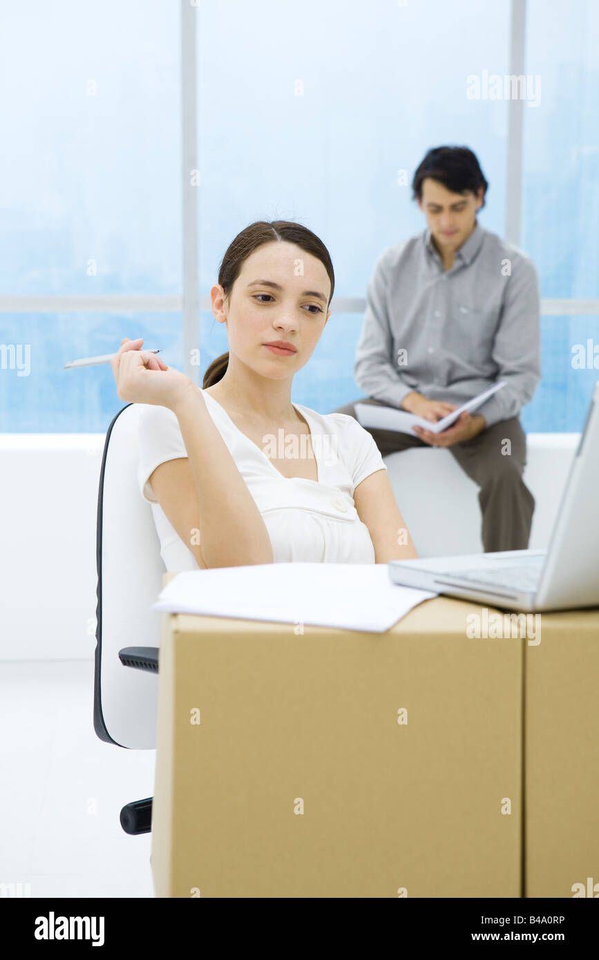 Junge Frau am Karton Schreibtisch, Laptop-Computer betrachten Stockfoto