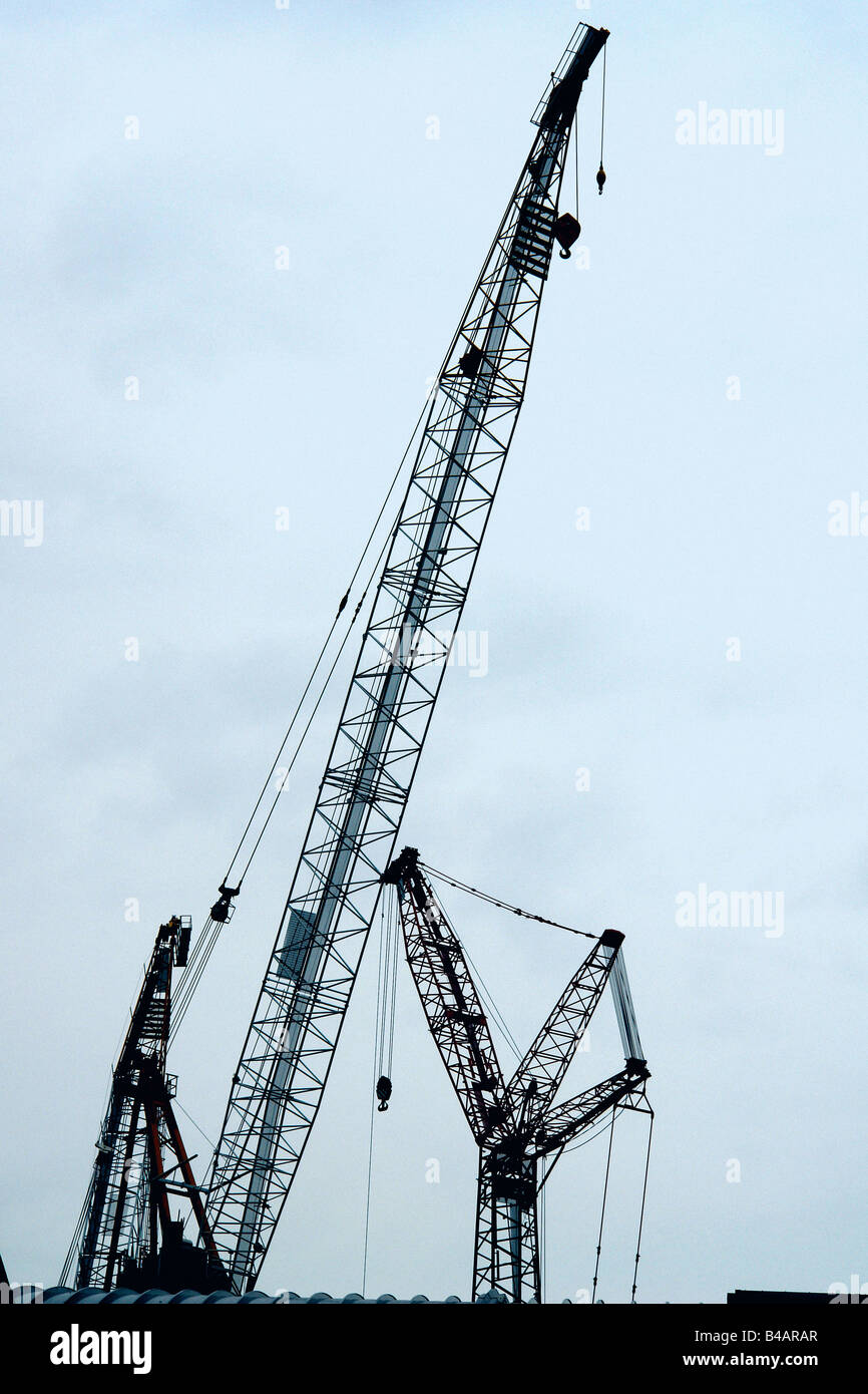 Städtischen Szene von zwei 2 Baukräne ein Bau Website betrachtet von unten und sind Silhouetted gegen den Himmel Textfreiraum Stockfoto