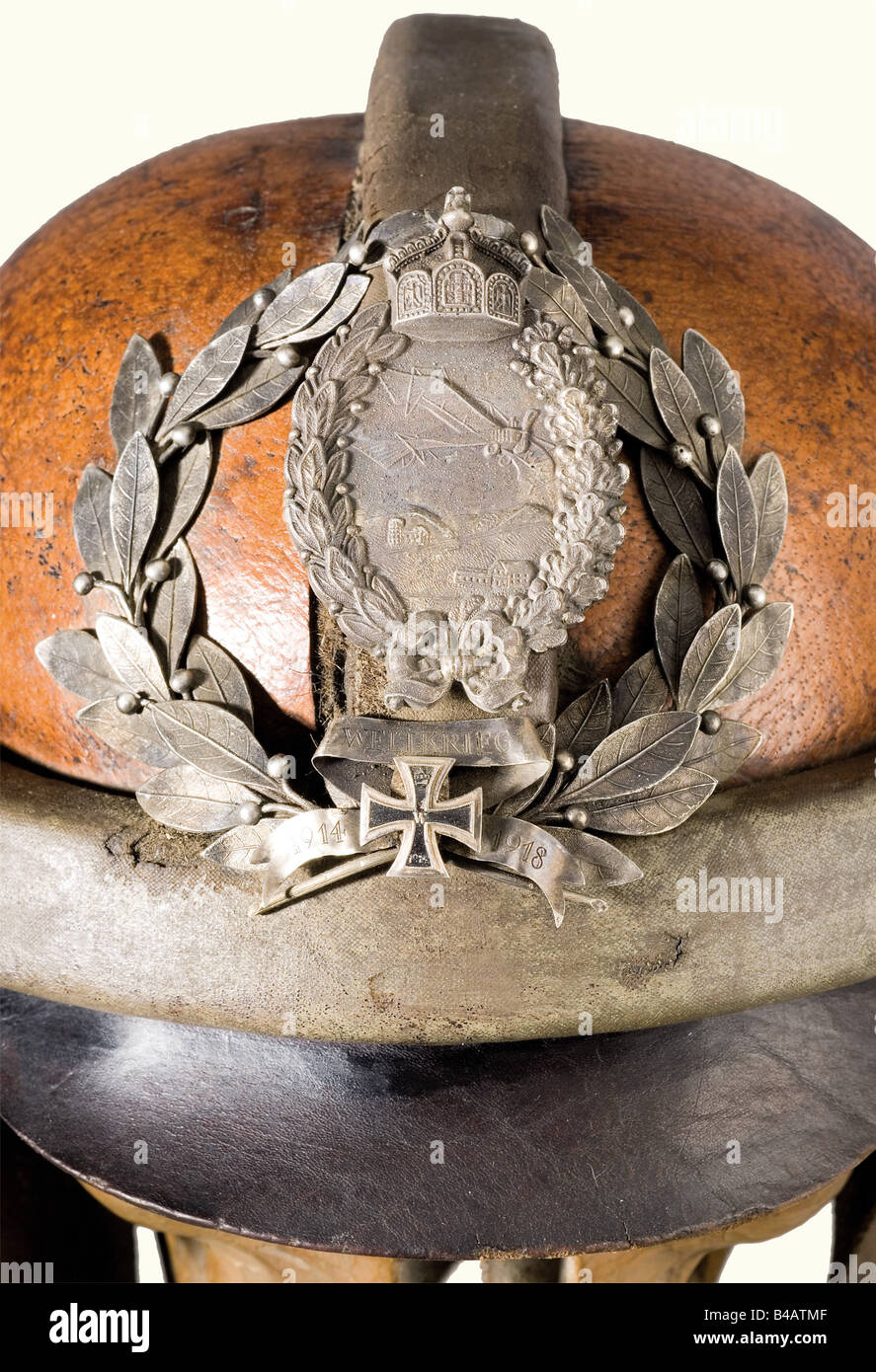 Ein Erinnerungsstück an mori für die deutschen Flieger, an den Ersten Weltkrieg. Ein aus Fruchtholz geschnitzter Schädel mit einem Lederpilotenhelm, die Form des Helms mit der Aufschrift "Flg.Bekl. Döberitz 1918", und das Visier ist mit dem Prägestempel "Hans Amler Original" versehen. Das Insignia Des Militärpiloten (20. Jahr) ist auf dem Helm in einem Lorbeerkranz mit einem Miniatur-Eisenkreuz 1914 unter einer Schriftrolle "1914 Weltkrieg 1918" (1914 Weltkrieg 1918) angebracht. Ein eingerahmtes, modernes Foto eines echten Schädels mit Flyer-Helm und -Brille mit einer 50-Mark-Rechnung zwischen seinen Zähnen ist auf der Vorderseite angebracht o, Stockfoto