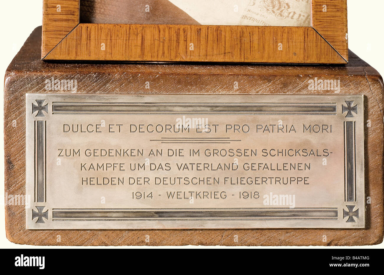 Ein Erinnerungsstück an mori für die deutschen Flieger, an den Ersten Weltkrieg. Ein aus Fruchtholz geschnitzter Schädel mit einem Lederpilotenhelm, die Form des Helms mit der Aufschrift "Flg.Bekl. Döberitz 1918", und das Visier ist mit dem Prägestempel "Hans Amler Original" versehen. Das Insignia Des Militärpiloten (20. Jahr) ist auf dem Helm in einem Lorbeerkranz mit einem Miniatur-Eisenkreuz 1914 unter einer Schriftrolle "1914 Weltkrieg 1918" (1914 Weltkrieg 1918) angebracht. Ein eingerahmtes, modernes Foto eines echten Schädels mit Flyer-Helm und -Brille mit einer 50-Mark-Rechnung zwischen seinen Zähnen ist auf der Vorderseite angebracht o, Stockfoto