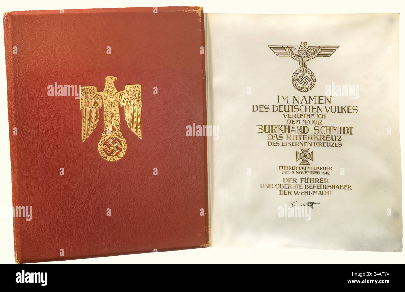 Major Burkhard Schmidt - eine Preisverleihung für das Ritterkreuz des Eisenkreuzes 1939 für den 6. November 1942., EIN großformatiges, doppelboges Pergamentdokument mit dem Text des Zitats in schwarzer Kalligraphie und hob Gold über die Unterschrift Hitlers in Tinte. Sehr gut erhalten, das Pergament ist leicht gefleckt und das Material zeigt eine gewisse Undulation. In der ursprünglichen Preismappe aus rotem Leder mit gestempelter Golddekoration ist die rechte Seite des mit Pergament überzogenen Innenraums signiert: "Frieda Thiersch". Sehr gut erhalten mit eingezogenen Ecken und ED, Stockfoto