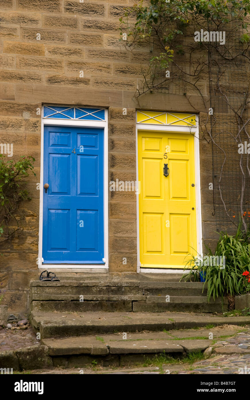 Angrenzende Türen lackiert, hellblau und gelb an Robin Hoods Bay North Yorkshire England Stockfoto