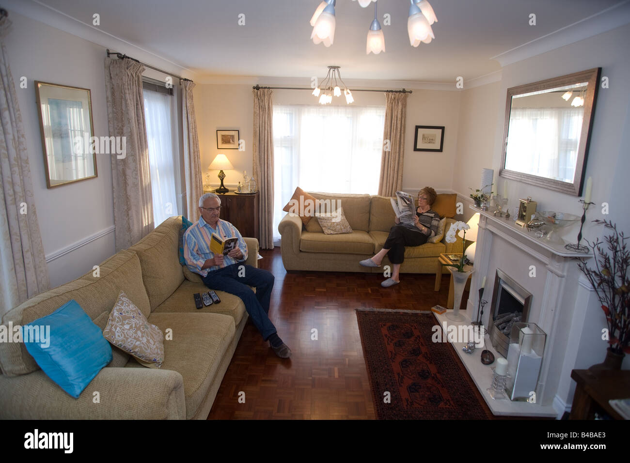 Ältere Mann und Frau entspannen Lesung in der Lounge des Hauses Stockfoto