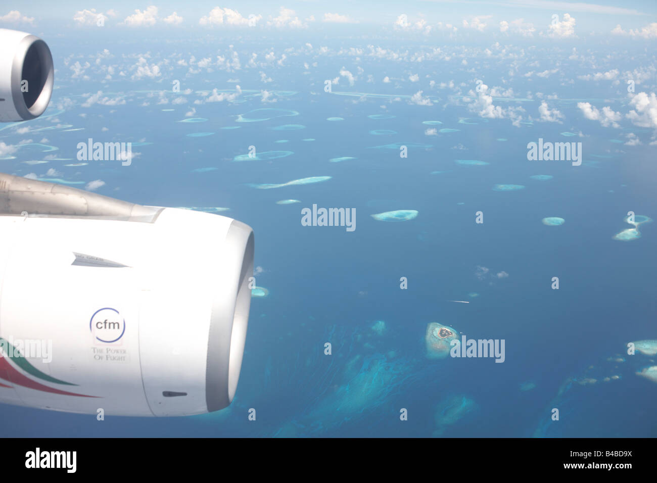 Ein Blau des Indischen Ozeans und entfernten Atollen in der Republik der Malediven liegen weit unterhalb eines Airbus Hafen Flügel und Triebwerke von CFM Stockfoto