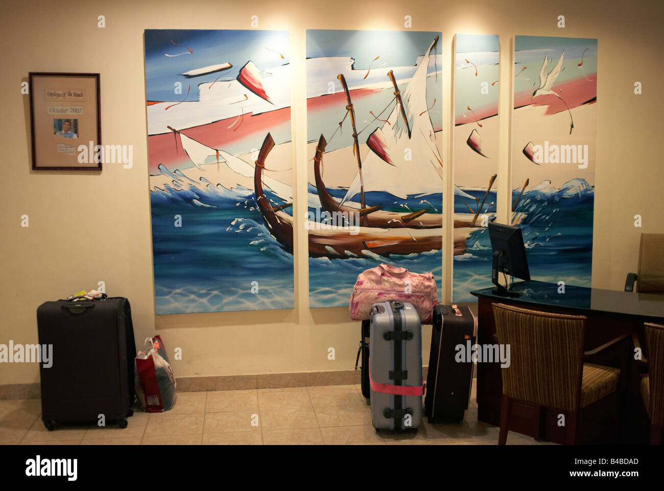Touristischen Gepäck bleibt an einer Rezeption in der Lobby gegen ein Wandbild zeigt traditionellen maledivischen Dhoni Angelboote/Fischerboote Stockfoto