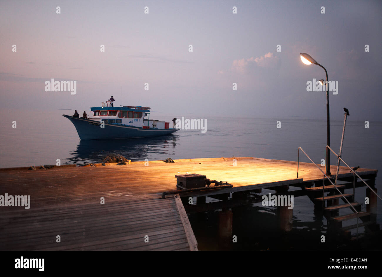 Fischer von einer Anlegestelle in der Morgendämmerung aufbrechen, um Fisch für Gelbflossenthun an Bord einer traditionellen Dhoni-Boot am Indischen Ozean Stockfoto