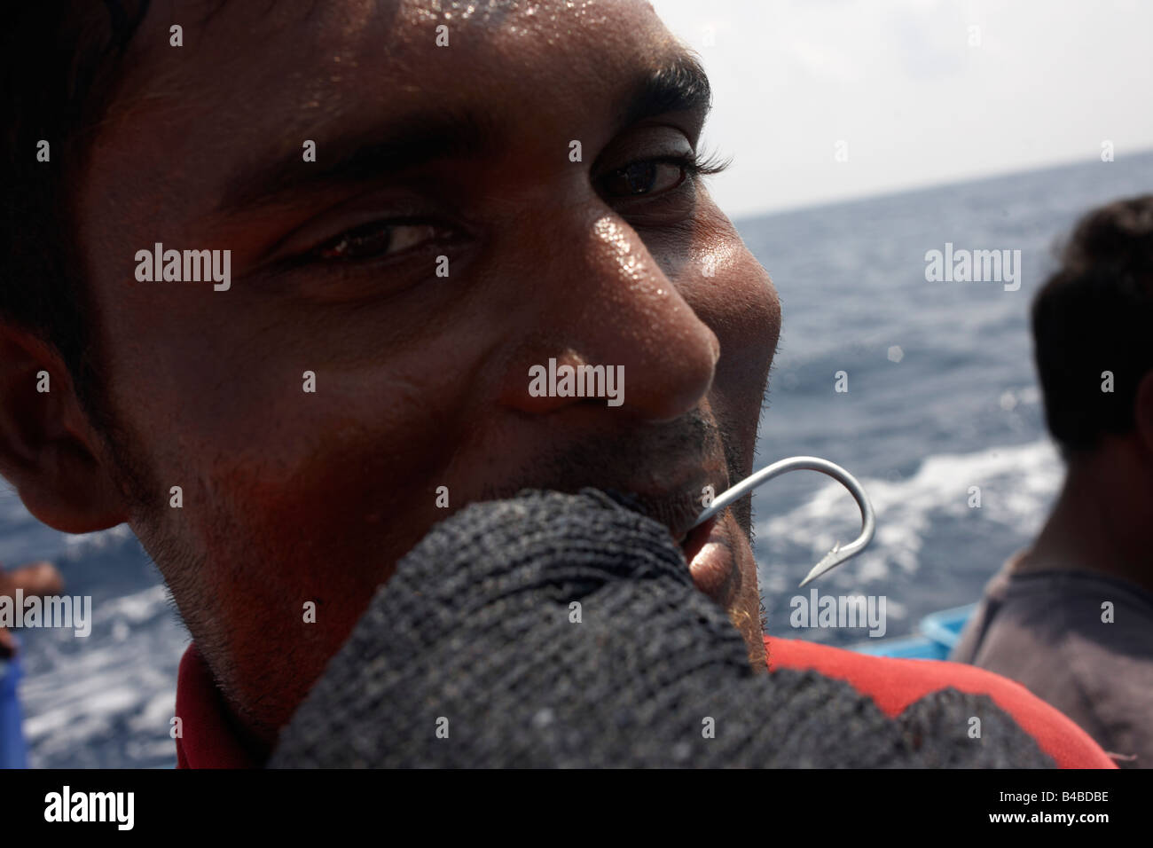 Ein maledivischer Fischer zeigt einen Haken und Mesh Handschuh zur Linie fangen Gelbflossen-Thunfisch auf einem Dhoni-Boot, Indischer Ozean Stockfoto