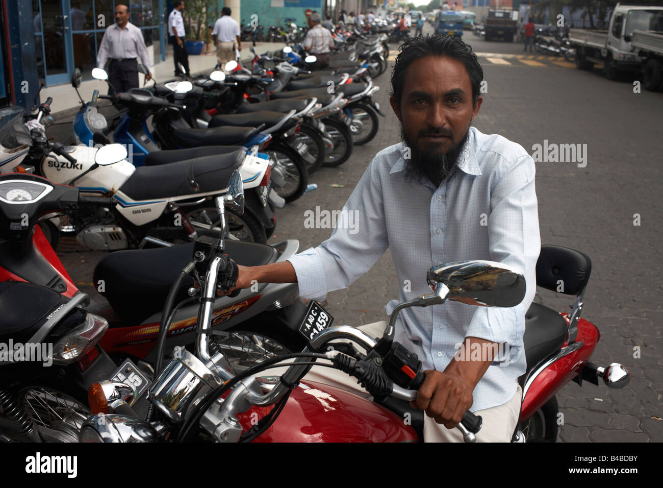 Ein Helm weniger muslimischen Fahrer sucht einen Parkplatz für sein Motorrad in einer überfüllten engen städtischen Straße von Malé, Malediven Stockfoto