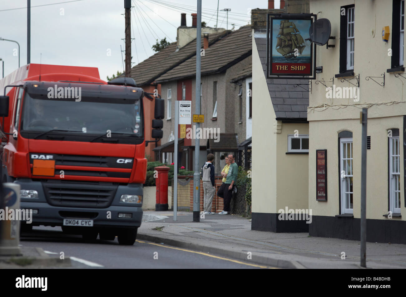 Eine schwere Lastkraftwagen (LKW) donnert letzten Häuser und das Schiff Pub auf der A126 in industriellen Grays, Thames Gateway Stockfoto