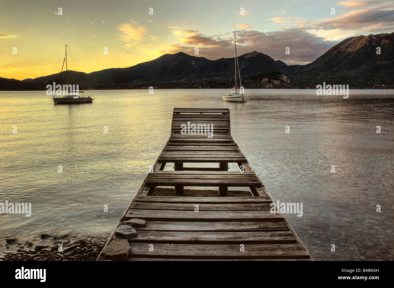 Erste Sonnenstrahlen tanzen über die Alpen an den Lago Maggiore, Italien Stockfoto