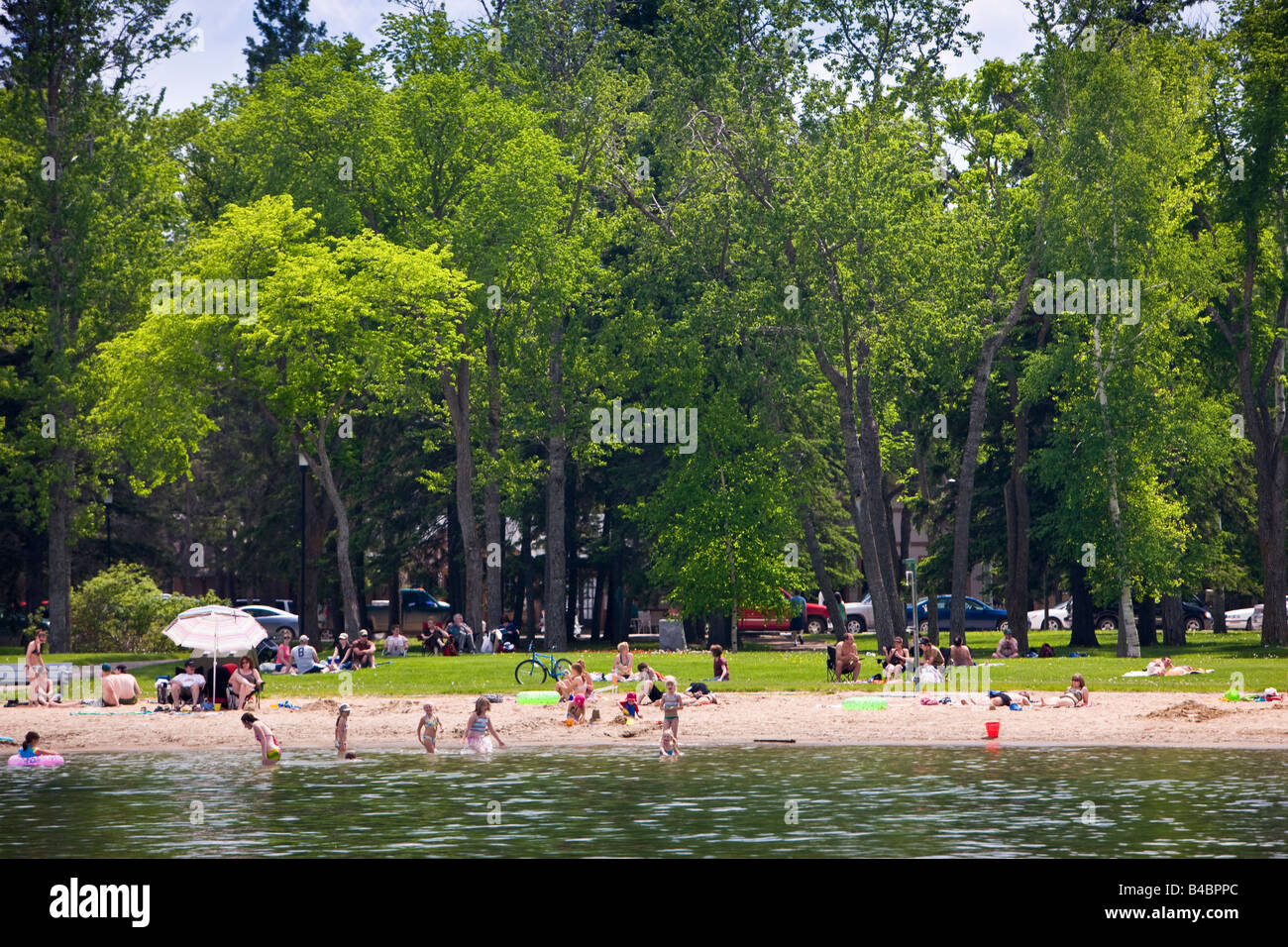 Entspannte Urlauber am Sandstrand von Clear Lake in Wasagaming, Riding Mountain National Park, Manitoba, Kanada. Stockfoto