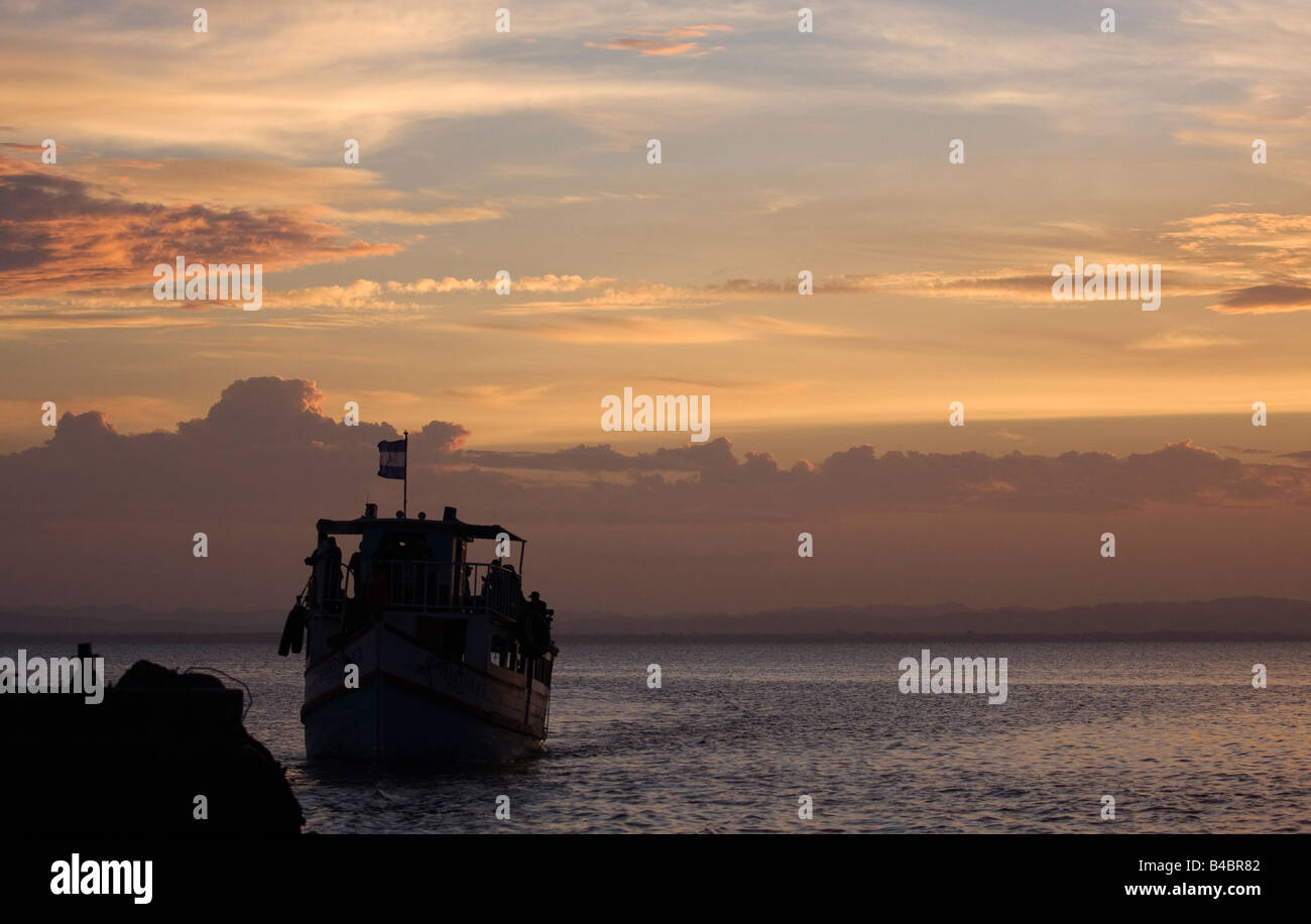 Eine Flagge fliegen, die letzte Fähre des Tages bei Sonnenuntergang in der Stadt ankommt dock in Moyagalpa auf der Insel Ometepe im Nicaragua-See. Stockfoto