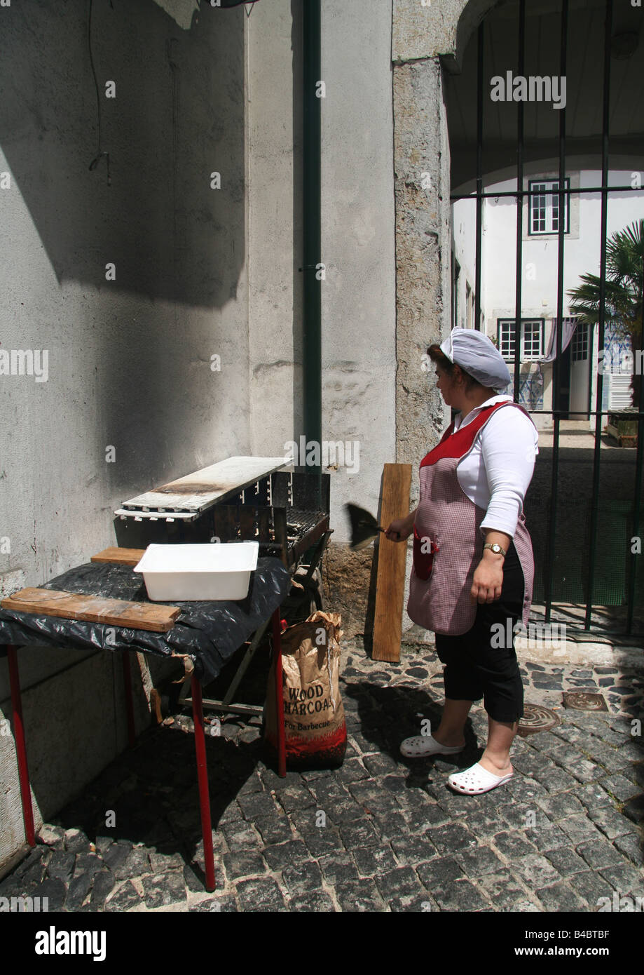 Chefkoch Grillen Sardinen auf BBQ in der Alfama Stockfoto