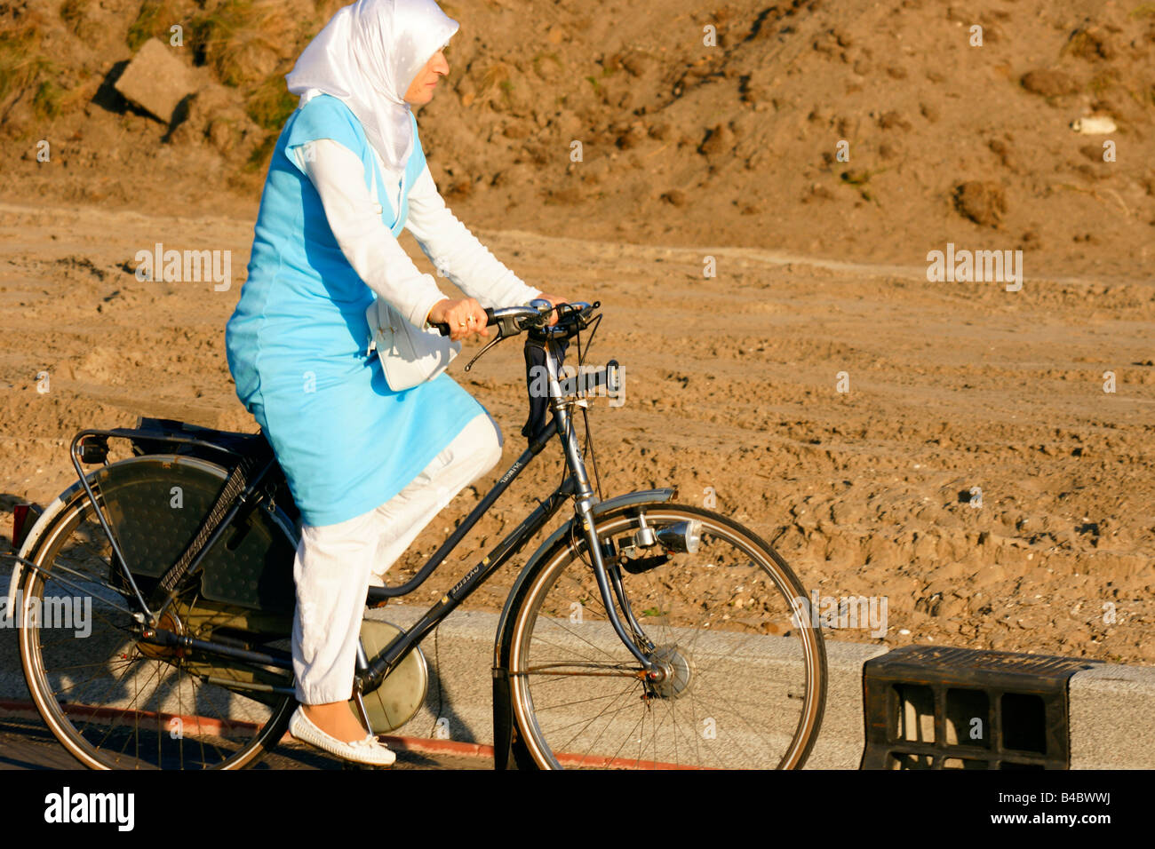 Moslim Muslem Frau Zyklus Fahrrad gekleidet im traditionellen arabischen  Stil mit Kopftuch in Niederlande Stockfotografie - Alamy