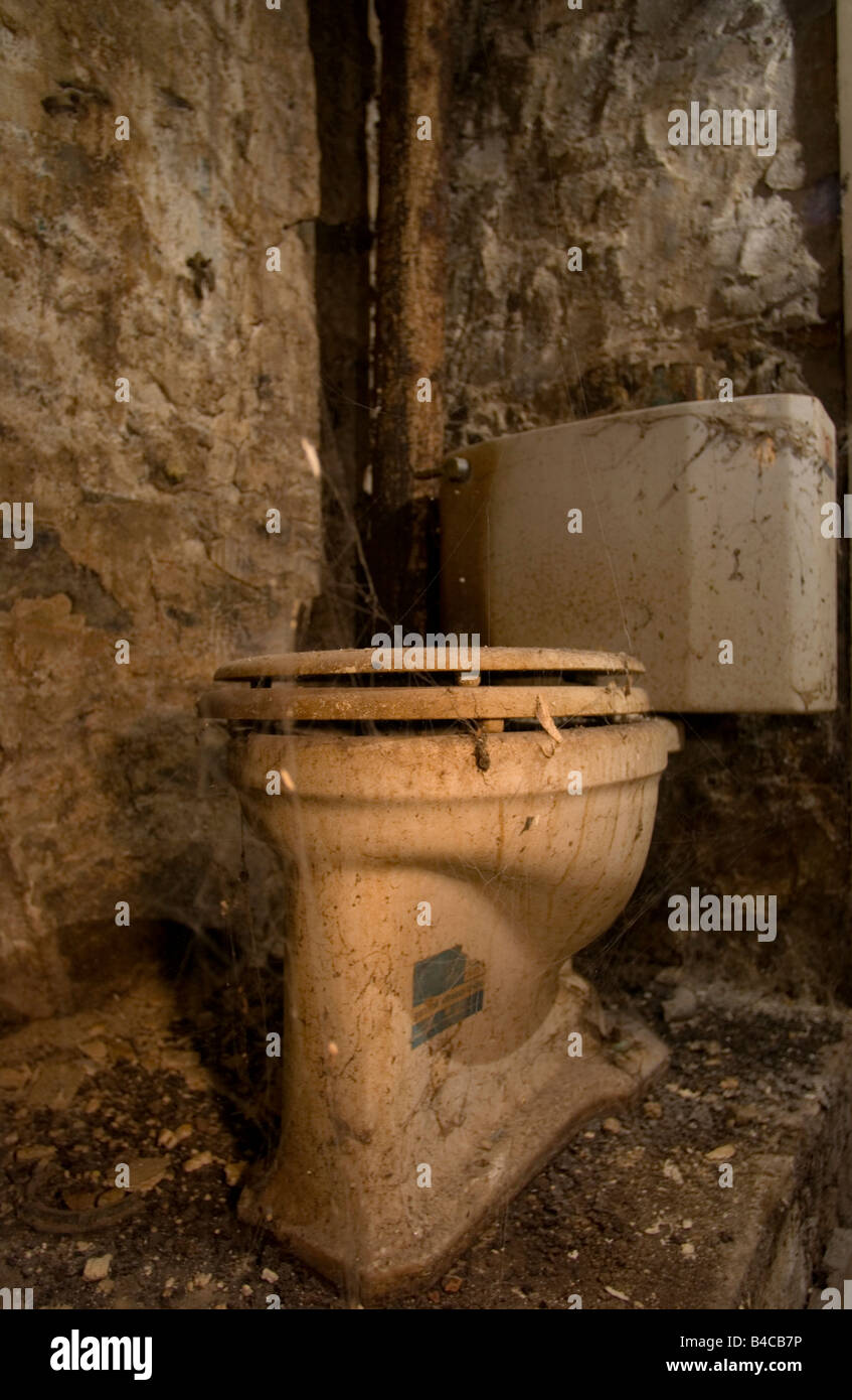 Ekelhaft schmutzige Toilette in einem alten verfallenen Reihenhaus. Stockfoto