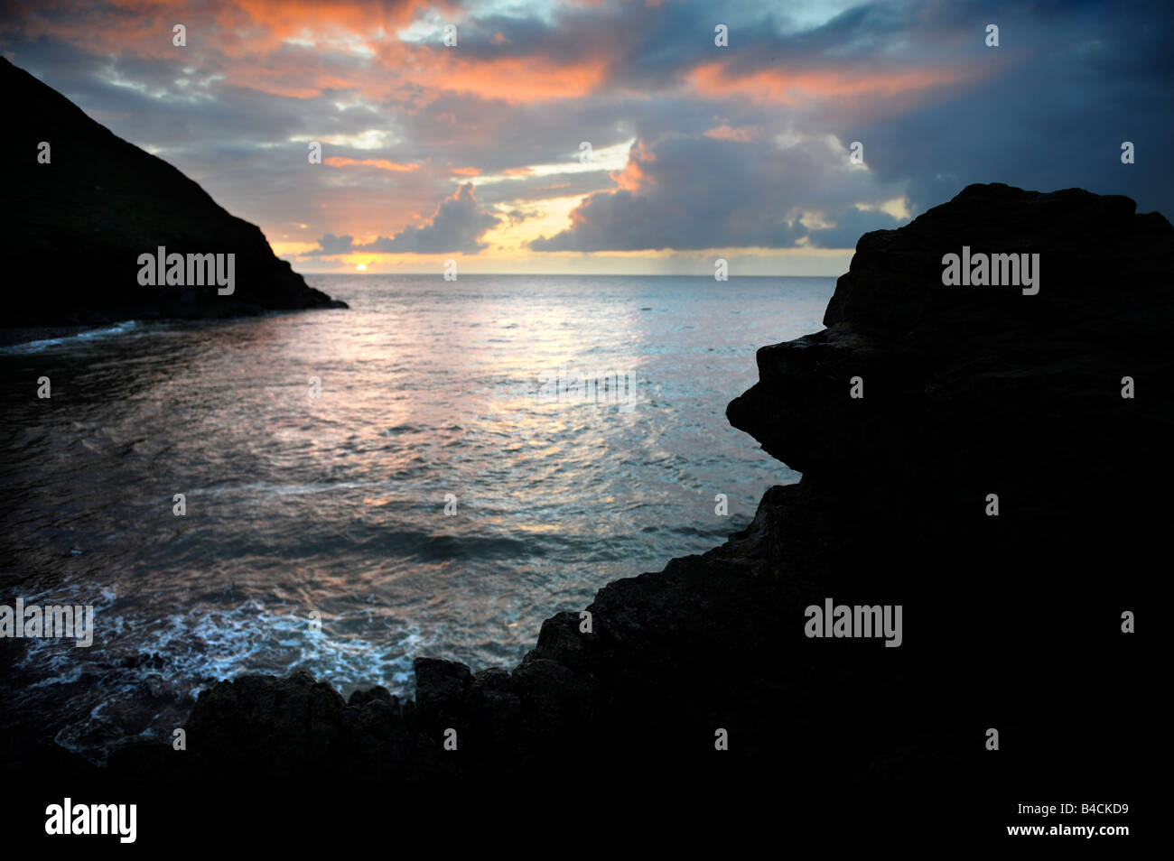 SONNENUNTERGANG IN DER BUCHT BEI CWMTYDU BAY CEREDIGION WEST WALES UK Stockfoto