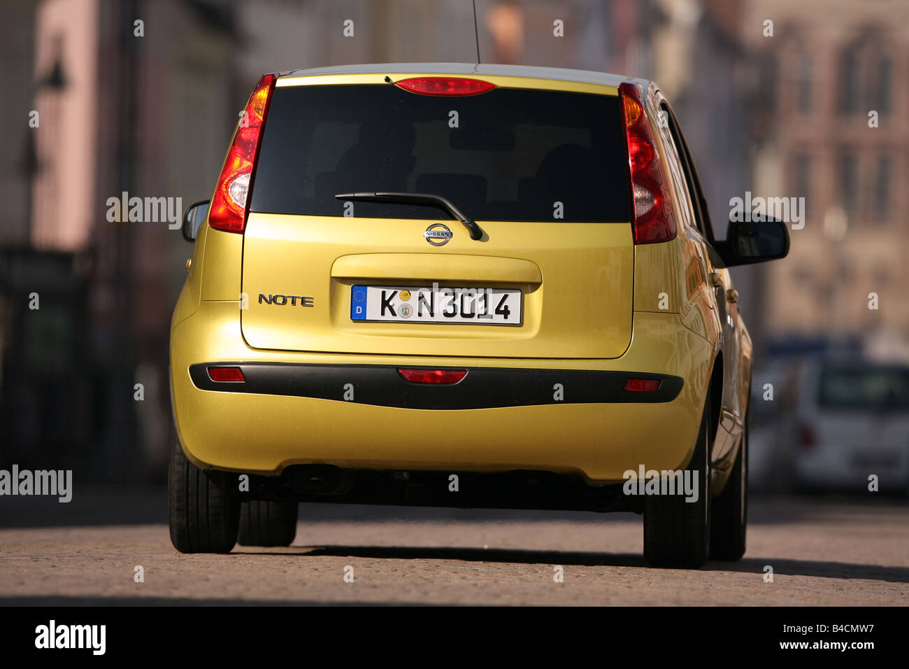 Nissan Bewertung 1,4, Modelljahr 2006-gelb, fahren, diagonal von hinten, Rückansicht, Stadt Stockfoto