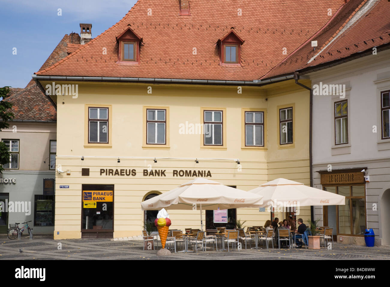 Hermannstadt Siebenbürgen Rumänien Europa Piraeus Bank im Altbau durch Straßencafé in Piata Mare im historischen Zentrum der Stadt Stockfoto