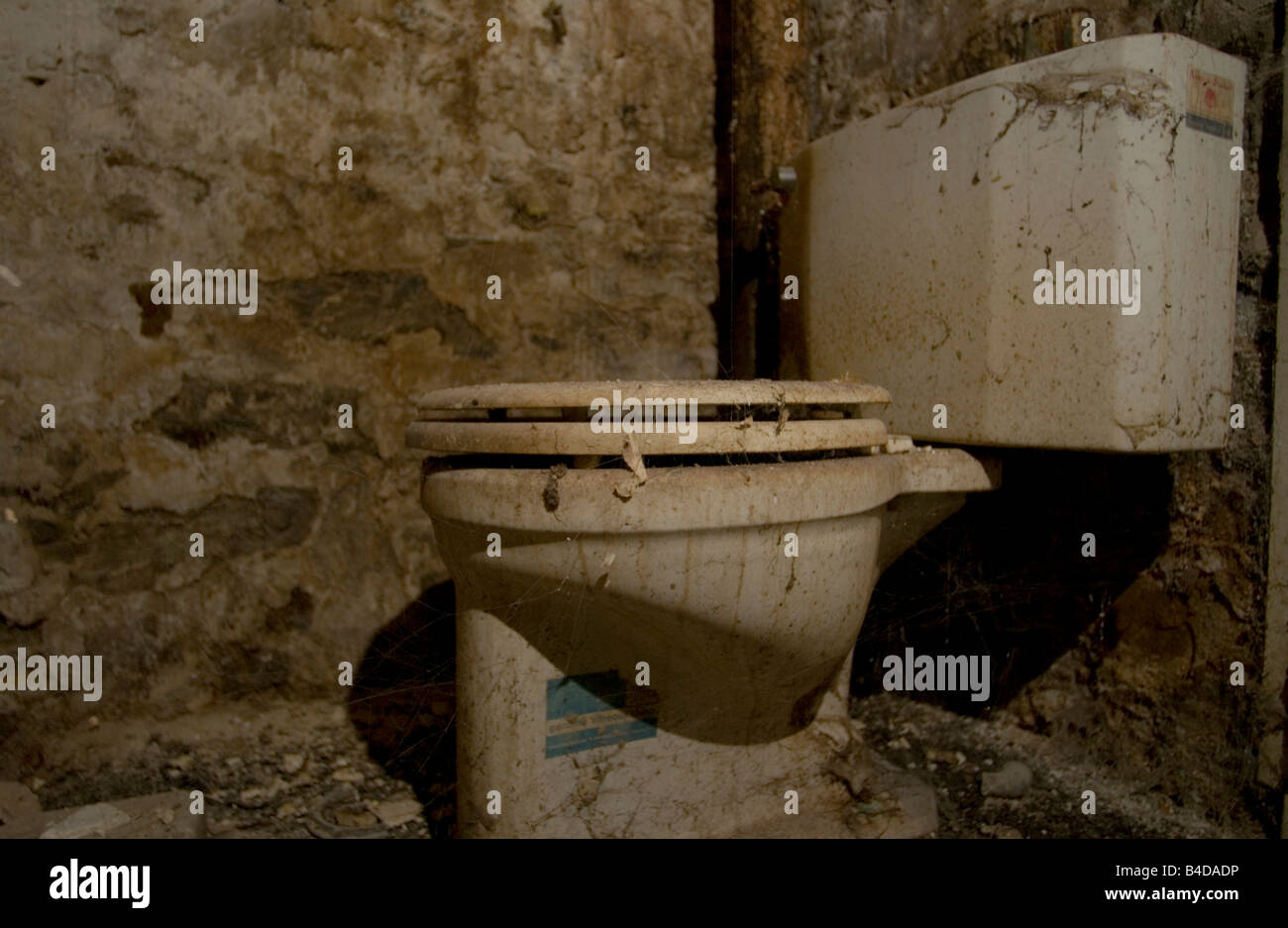 Ekelhaft schmutzige Toilette in einem alten verfallenen Reihenhaus. Stockfoto