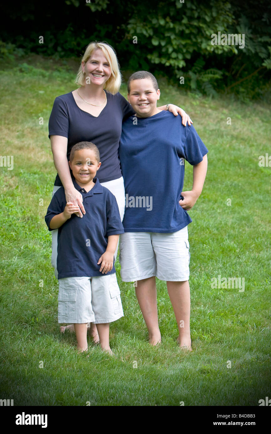 Hübsche Mutter mit ihren beiden Söhnen draußen auf dem Rasen Stockfoto