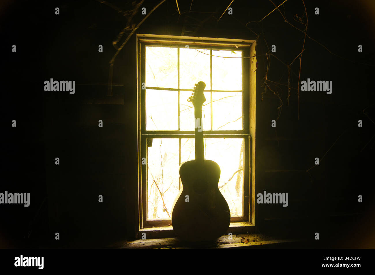 Alte Gitarre Silhouette im Fenster Stockfoto