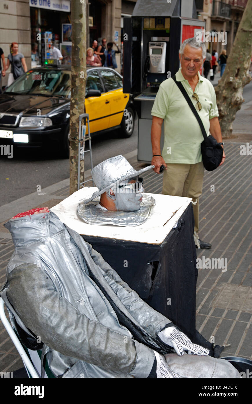 Mann beobachtet menschliche Statue Straßenkünstler auf der la Rambla in Barcelona, Spanien Stockfoto