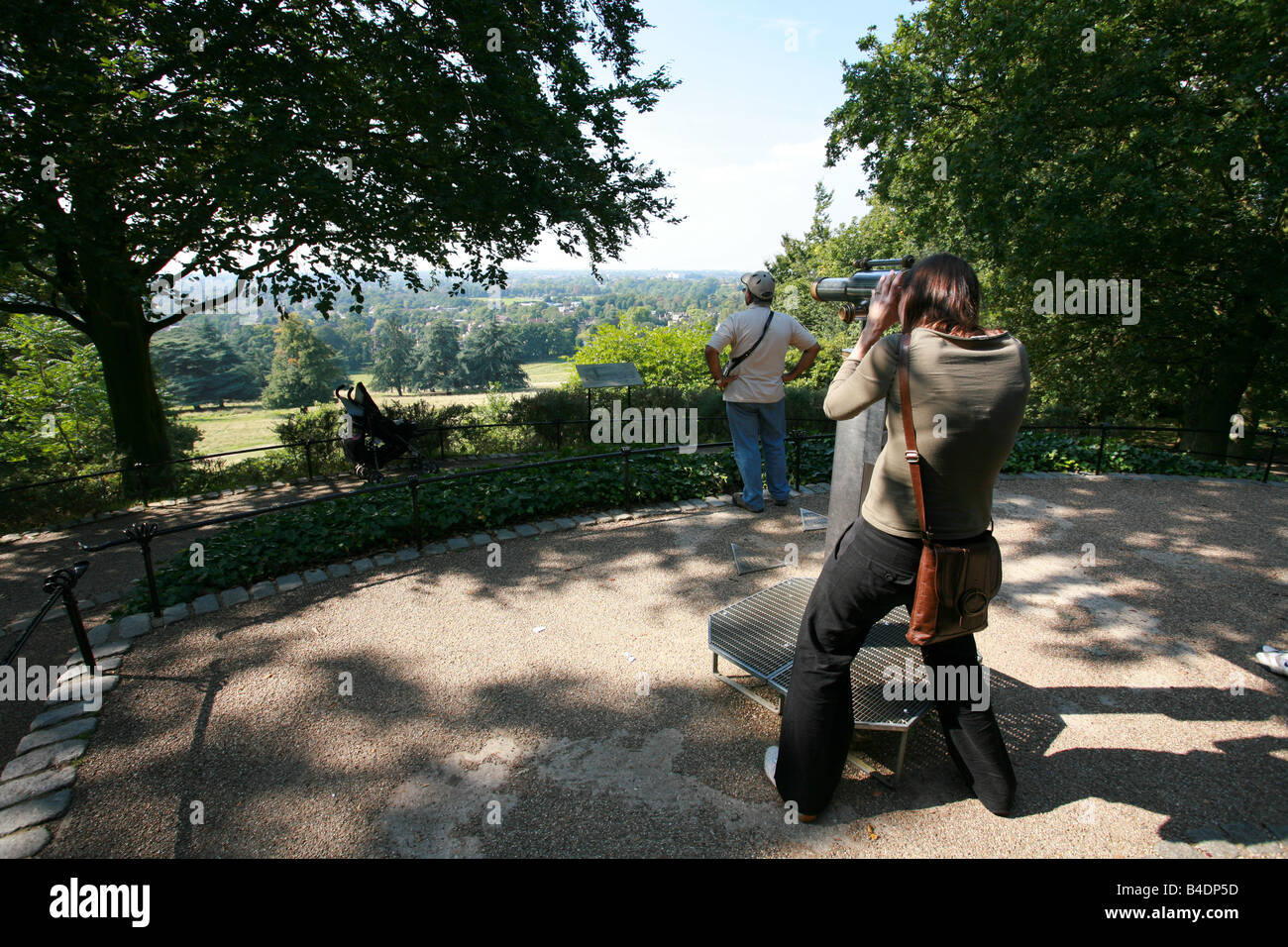 Junge weibliche Touristen Besucher Richmond Park nutzt kostenlose Teleskop Thames Valley Surrey Landschaft aus St. Henrys Mount anzeigen Stockfoto