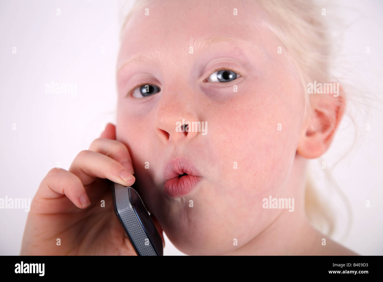 Kopf und Schulter Nahaufnahme Schuss ein wenig blonden Haaren, blauäugige Mädchen sprechen auf einem Handy/Mobiltelefon Stockfoto