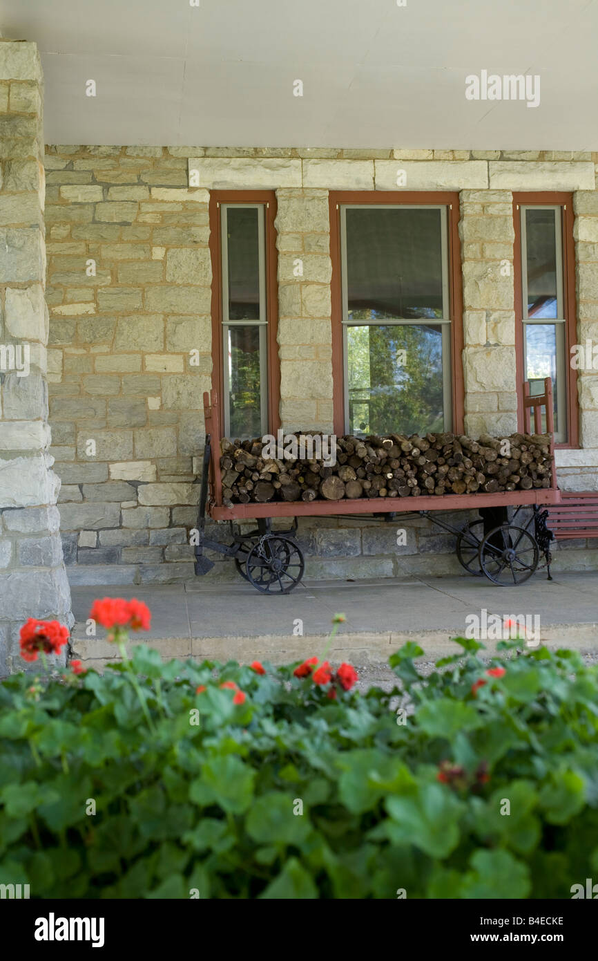 Eisenbahn-Gepäckwagen ist vollgepackt mit Holz auf dem Bahnhof Stockbridge in Stockbridge, Massachusetts und Geranien blühen Stockfoto